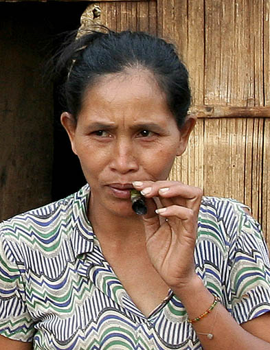 Many Phnong ladies like to smoke home-made cigars. Pu Tang Village, Mondulkiri, Cambodia