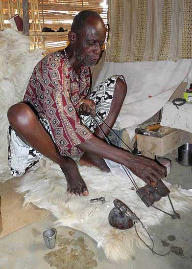 Fetish priest in Atsiekpoe. When the ancestors agree to help, he can pull the small mask towards him, otherwise it is blocked.
