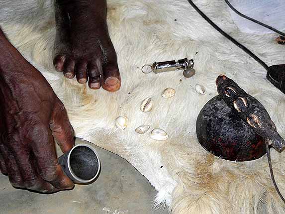 Fetish priest in Atsiekpoe offering alcohol to the ancestors before starting a ceremony.