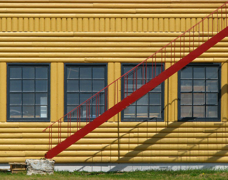 escalier rouge et maison jaune
