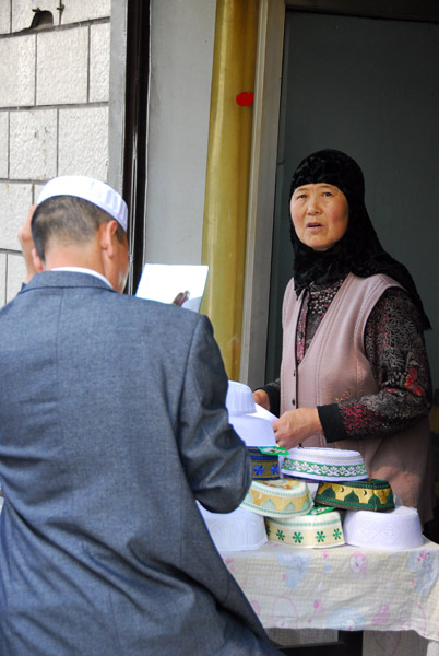 Chinese Muslim woman selling Islamic men's caps, Xining