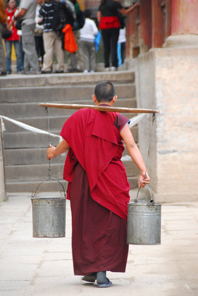 Monk fetching pails of water
