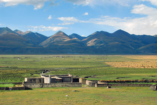 Sturdy rural Tibetan dwelling on the edge of the vast plain