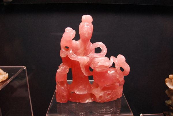 Statuette in rose quartz of a lady playing with a lion