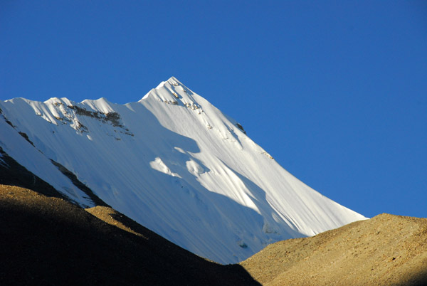 The morning sun reaches the white peak west of Rongphu