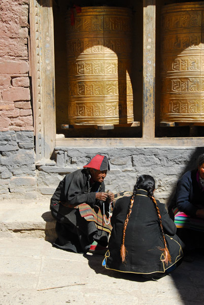 Tibetans in front of large prayer wheels, Sakya