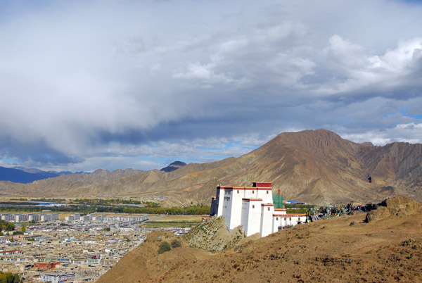 Shigatse Dzong as we climb higher towards a saddle marked with prayer flags