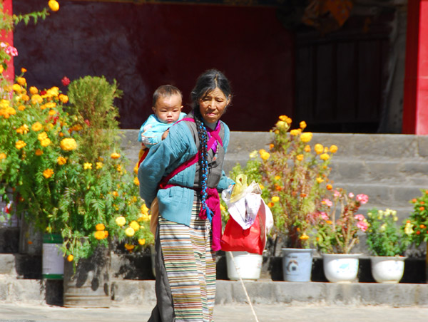 Tibetan woman carrying a baby on her back