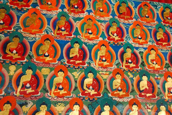 Thousands of small Buddha images painted on the cloister walls around the central courtyard of the Kelsang Temple Complex