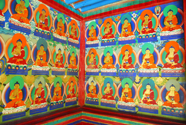Thousands of small Buddha images painted on the cloister walls around the central courtyard of the Kelsang Temple Complex