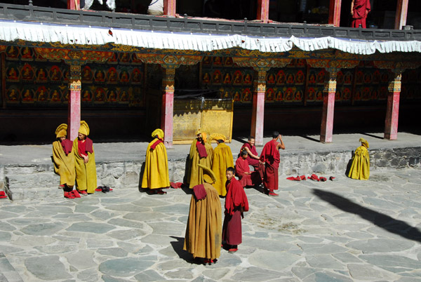 Monks gathering in the courtyard of Kelsang Temple Complex for noon prayers