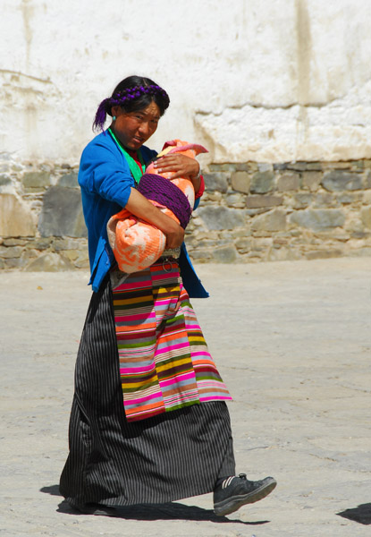 Tibetan woman carrying a bundled up child