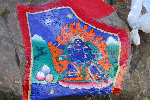 Thangka style painting of a Wrathful Deity painted on a rock