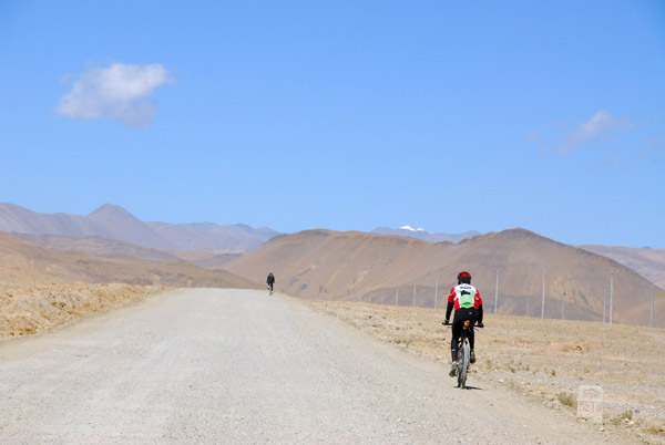 Cyclists passing km 5219 on the Friendship Highway - 167 km to go to the Nepal border