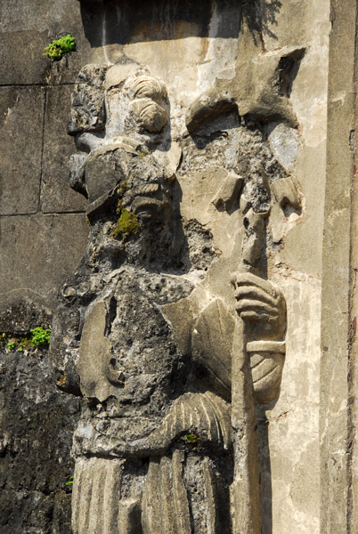 Damaged figure on the left side of the main gate