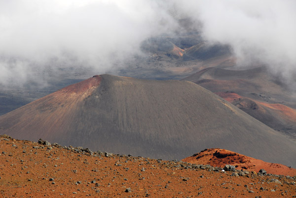 Pu'u o Maui, a cinder cone in the crater of Mount Haleakala, partially obscured by cloud