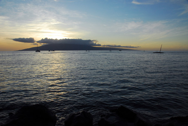 The sun setting over cloud-capped Lanai