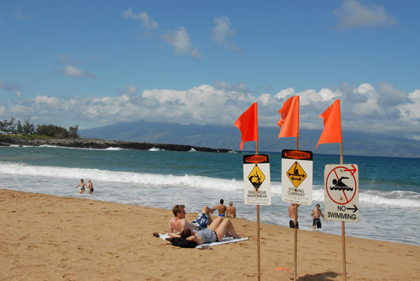 Warning signs, Fleming Beach Park, with Maui Makalua-puna Point and Molokai