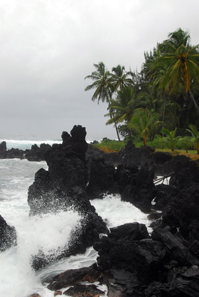 Waves crashing against the black lava