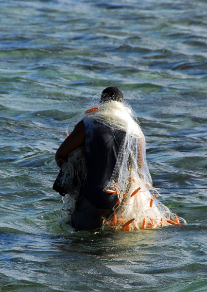 Chamorro fisherman wading with his nets off Paseo de Susana