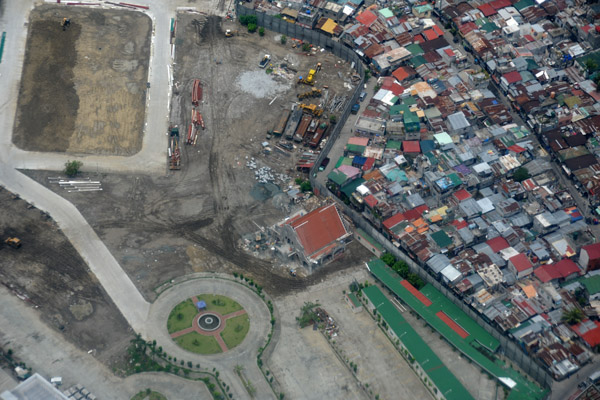 New construction walled off from a shanty town, suburban Manila (N14.477/E120.993)