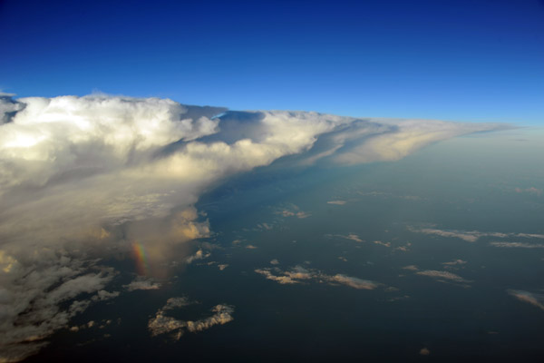 Thunderstorm with a huge anvil and small rainbow off southern Borneo