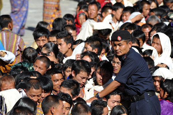Bhutanese policemen keeping the pilgrims in an orderly line