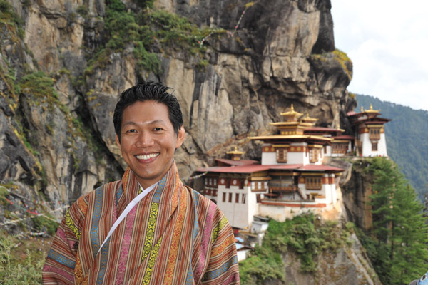 Dennis wearing his Bhutanese gho poses with the Tiger's Nest as a background