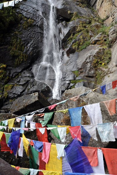 Waterfall and prayer flags in the gorge