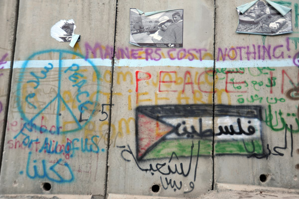 West Bank Separation Wall graffiti - Manners cost nothing! - Palestinian flag with فلسطين