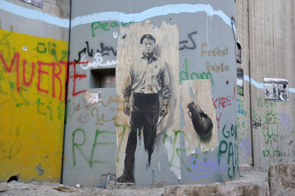 West Bank Separation Wall graffiti - quality painting of broken pottery and a man holding a piece of paper