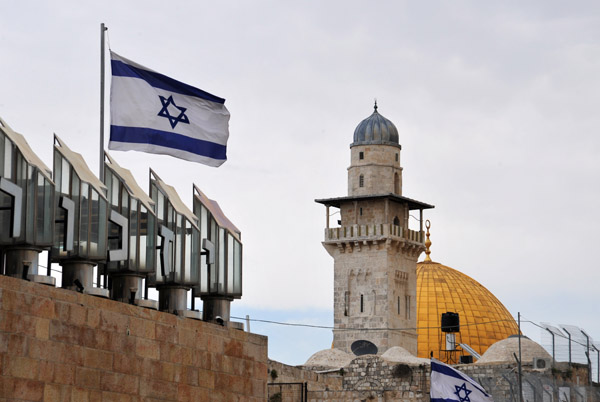 Israeli flag over Western Wall Plaza with the Dome of the Rock and the Fakhriyya Minaret