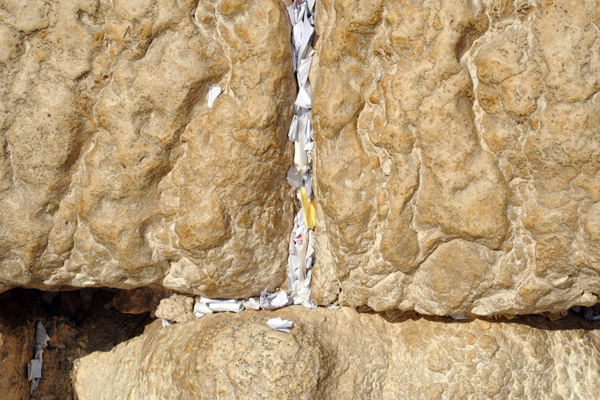 Prayers written on scraps of paper wedged between the stones of the Western Wall
