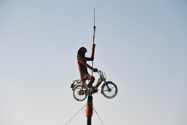 Figure riding on moped on a post near the north end of the Dead Sea