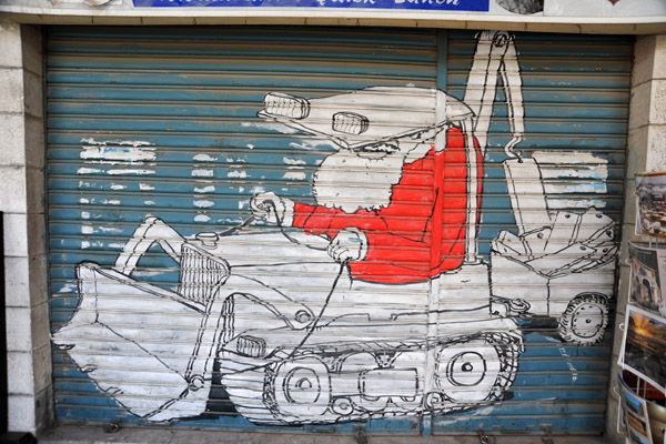 Santa Claus driving a bulldozer constructing the West Bank Separation Barrier