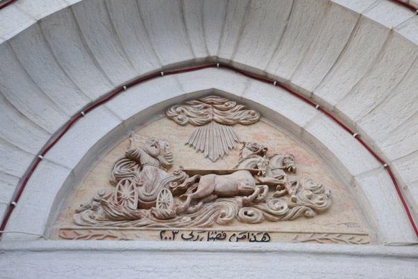 Carving above a doorway with a horse drawn carriage dated 2003