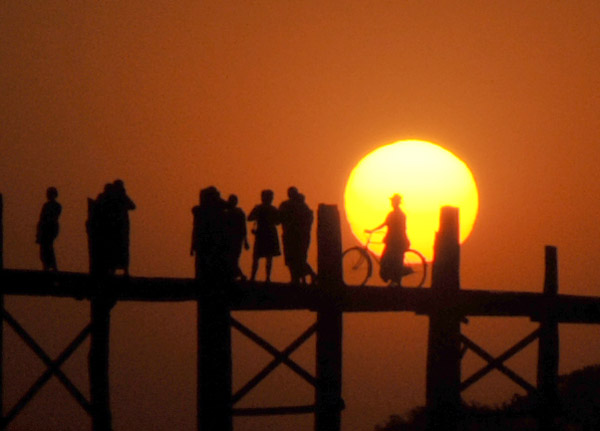 Silhouettes of villagers and a bicycle with the setting sun, Amarapura Teak Bridge