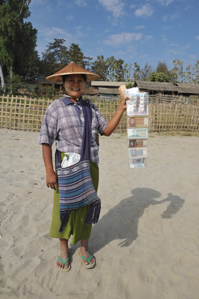 Burmese girl selling old banknotes and coins