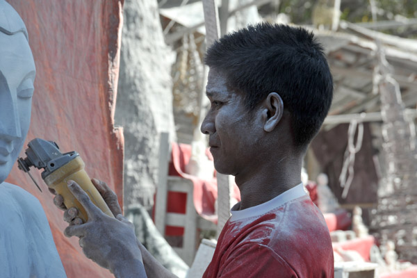 Young Mandalay stone carver covered in dust