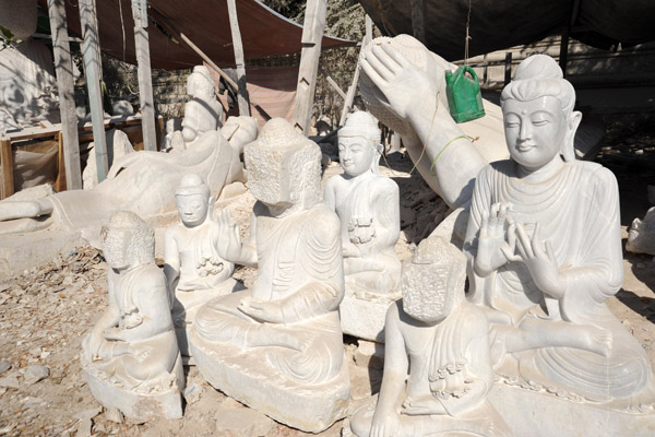 Some Buddhas awaiting their faces - probably the junior carvers do the body