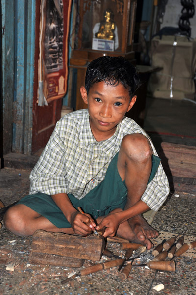 Very young woodcarver at work in the arcade leading to Mahamuni Paya