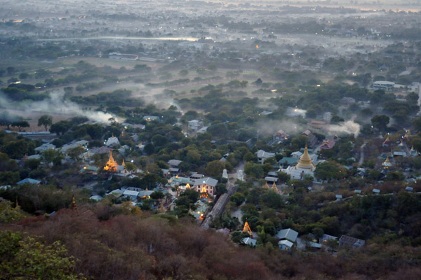 Smoke among the trees and buildings of Mandalay