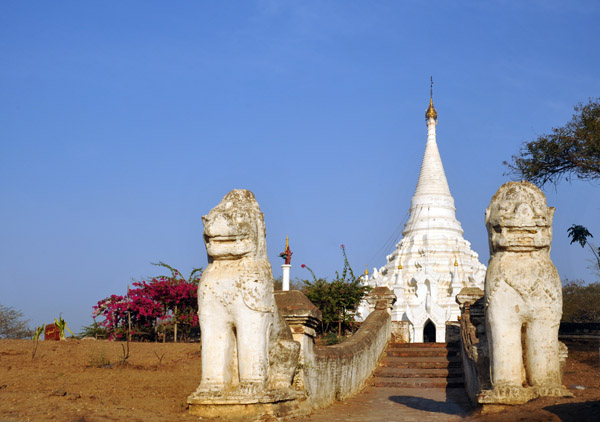 White pagoda guarded by Chinthe near the start of the grand arcade to Shwezigon, Nyaung U