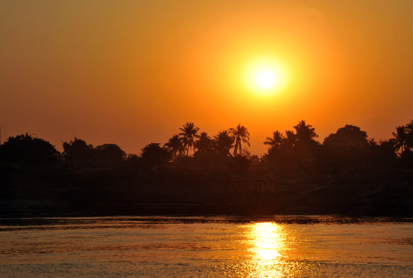 Sunrise with palm trees on the banks of the Irrawaddy River