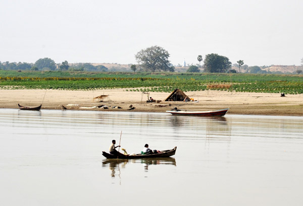 Fishermen and a small hut on the riverside floodplain