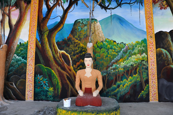 New Buddha statue in front of a mural of Mt. Popa