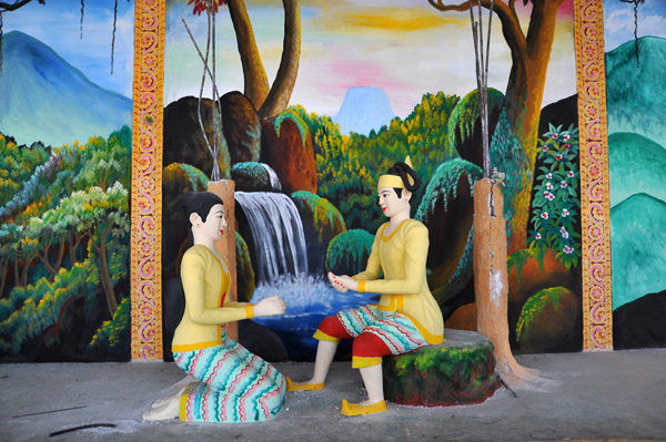 Two female figures in front of a painting of a waterfall at Mt. Popa