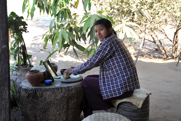 Burmese woman grinding Thanaka, the traditional powder make-up