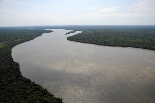 The broad Iguau River above the falls separating Brazil, on the left, from Argentina 