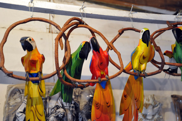 Colorful carvings of parrots with long tails, Cachoeira do Campo